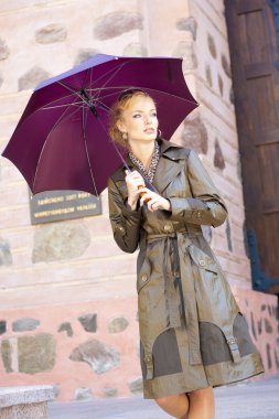 Beautiful Young Woman with umbrella Against the backdrop of bui clipart
