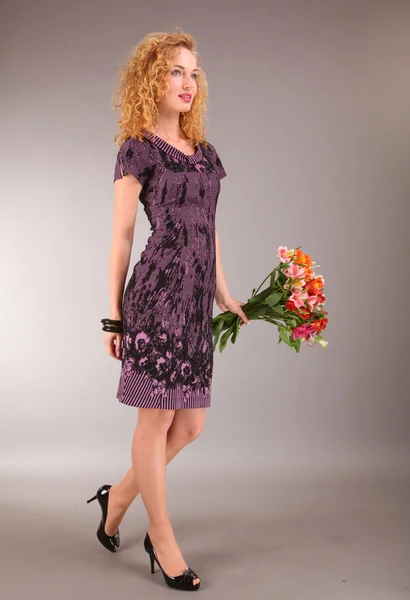 灰色の背景上に花と光の美しい若い女性ドレスアップします — ストック写真