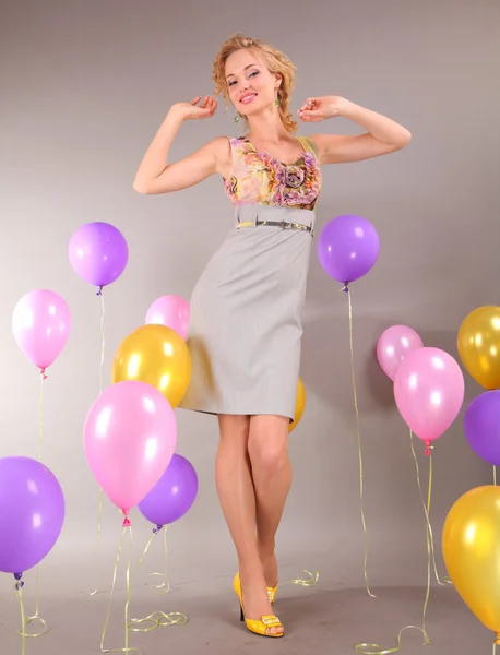 Piękna dziewczyna w jasną suknię na tle balony — Zdjęcie stockowe