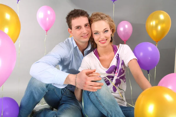 Jonge liefde paar lacht met ballonnen — Stockfoto