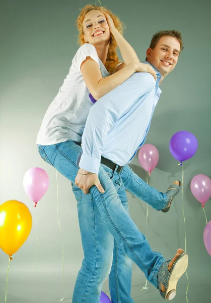 Mladá láska pár s úsměvem s balónky — Stock fotografie
