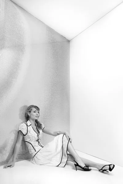 Красивая девушка в белом платье сидит на полу. В чёрном Шо — стоковое фото