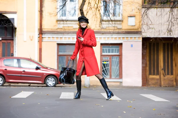 Dívka v červeném kabátě pohybuje venku — Stock fotografie