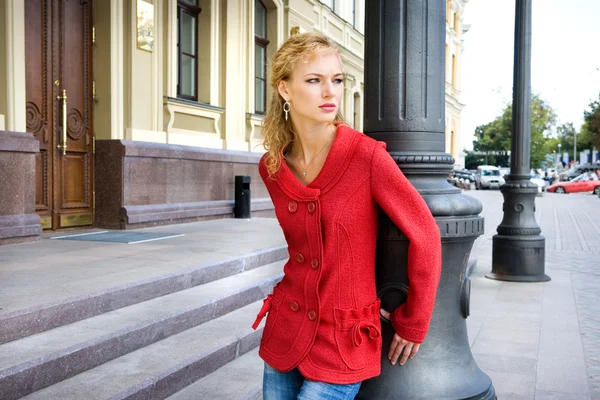 Vacker ung kvinna i röda kläder. mot bakgrund av b — Stockfoto