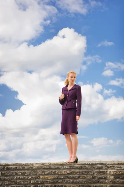 Beautiful Young Woman in suit, against backdrop of the bright cl — Stock Photo, Image