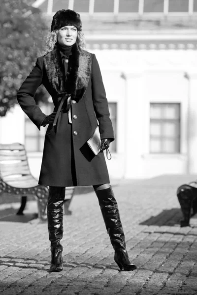 Linda loira de casaco e chapéu de pé ao ar livre — Fotografia de Stock