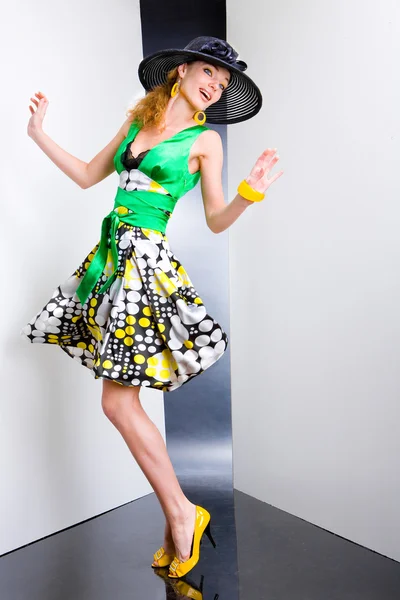 Jonge vrouw in een groene jurk en zwarte hoed. in alle groei. in th — Stockfoto