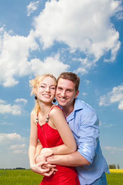 Mavi gökyüzü altında gülümseyen genç aşk Çift — Stok fotoğraf