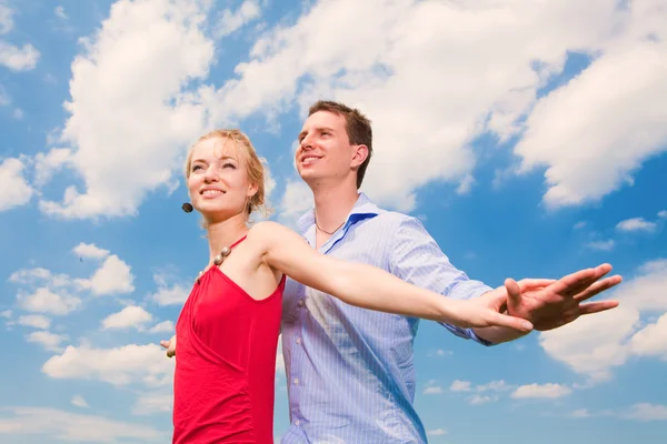 年轻的爱夫妇微笑在蓝蓝的天空下 — 图库照片