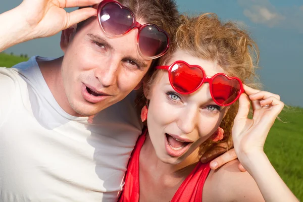 Ung kärlek par stirrar tog bort hans glasögon under blå himmel — Stockfoto