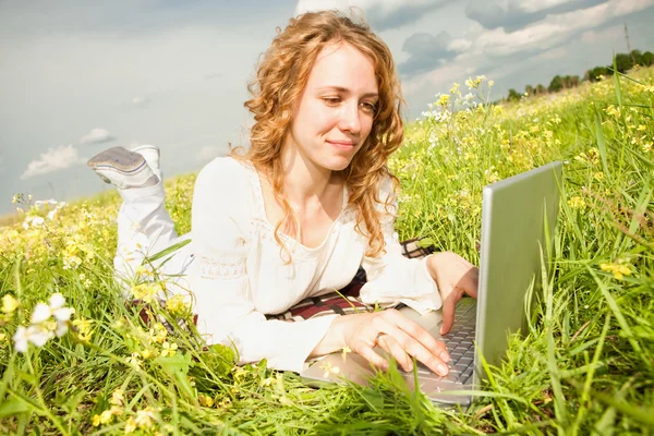Jovem Mulher Sentada Campo Grama Com Laptop Contra Pano Fundo — Fotografia de Stock