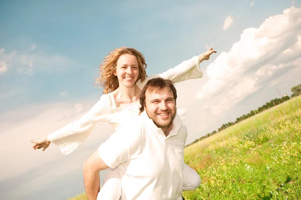 Junges Paar spaziert durch Sommerrasen — Stockfoto