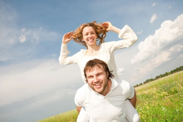 Young couple walking through summer lawn — Stock Photo, Image