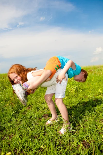 Dva ventilátor, děti si hrají na hřišti — Stock fotografie