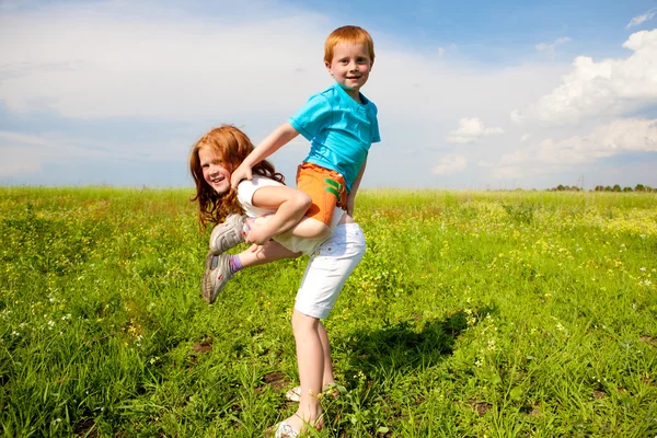 Dva ventilátor děti hraju pole — Stock fotografie
