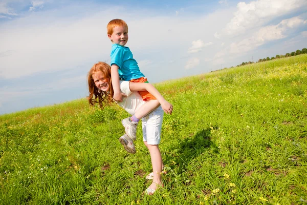 Dva ventilátor, děti si hrají na hřišti — Stock fotografie