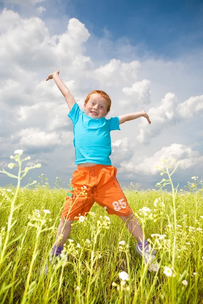 Gelukkige jongen springen het veld — Stockfoto