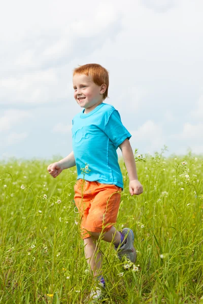 Šťastný chlapec běží proti krásné nebe — Stock fotografie