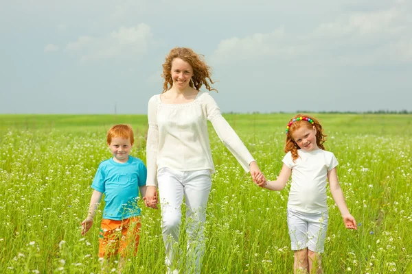 Mother with children goes on field — Stock Photo, Image