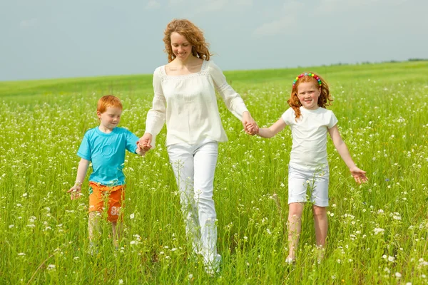 Mother with children goes on field — Stock Photo, Image