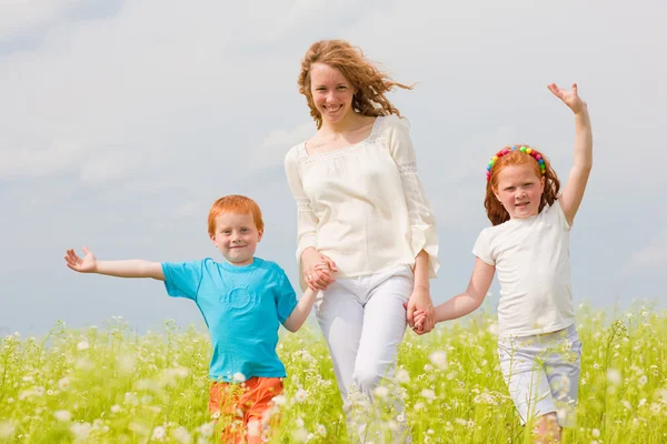 Moeder met kinderen plezier op veld — Stockfoto