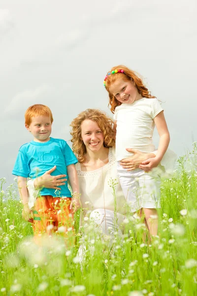 Een moeder met kinderen gaat op het veld — Stockfoto