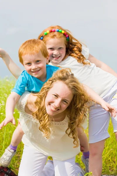 Matka s dětmi baví na poli — Stock fotografie