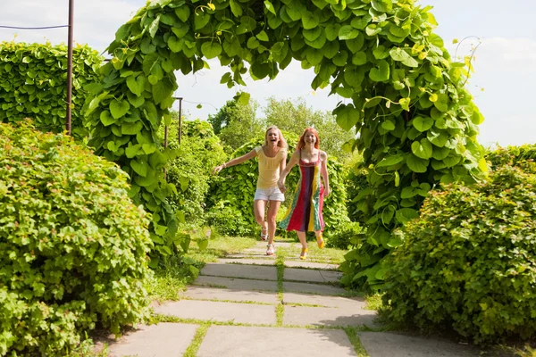 Due giovani donne felici corrono in un parco — Foto Stock