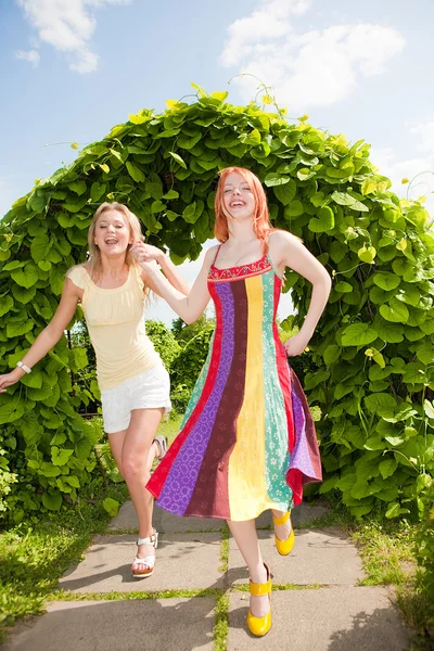 Zwei glückliche junge Frauen rennen in einem Park — Stockfoto