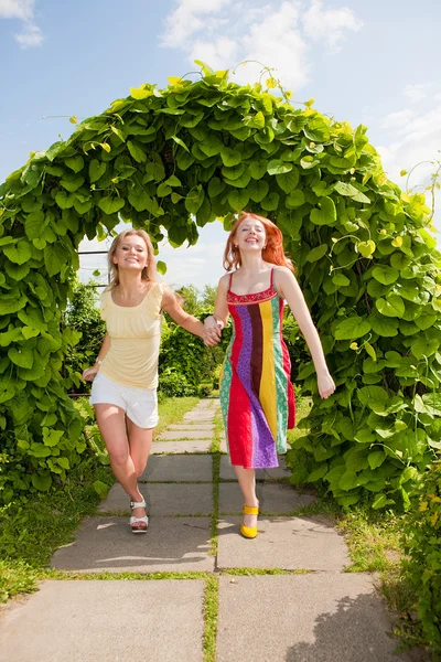 Zwei glückliche junge Frauen rennen in einem Park — Stockfoto