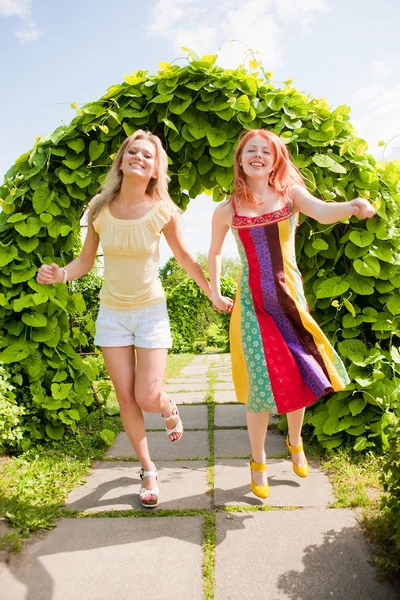 Dvě šťastné mladé ženy jsou spouštění v parku — Stock fotografie