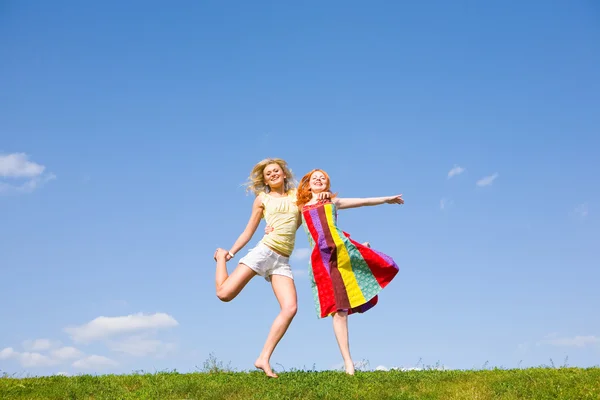 Δύο κορίτσια ευτυχισμένη που άλμα μαζί σε πράσινο λιβάδι. — Φωτογραφία Αρχείου