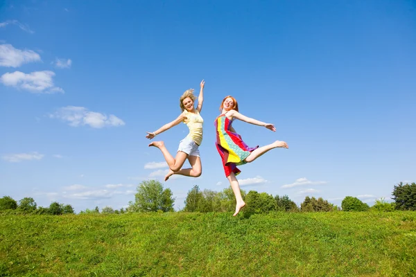 Zwei Glückliche Mädchen Springen Gemeinsam Auf Der Grünen Wiese — Stockfoto