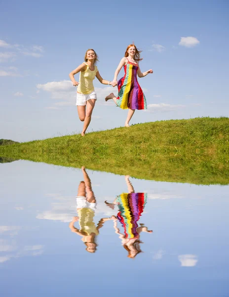 Дві щасливі дівчата стрибають — стокове фото