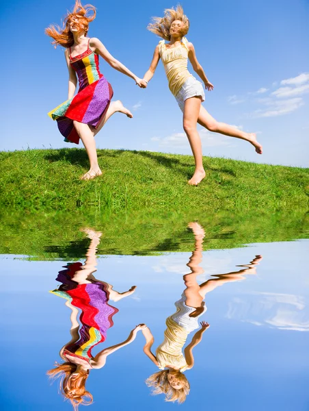 Due giovani donne felici corrono in un campo — Foto Stock