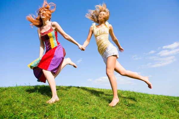 两个快乐的年轻妇女是运行在一个字段中 — 图库照片