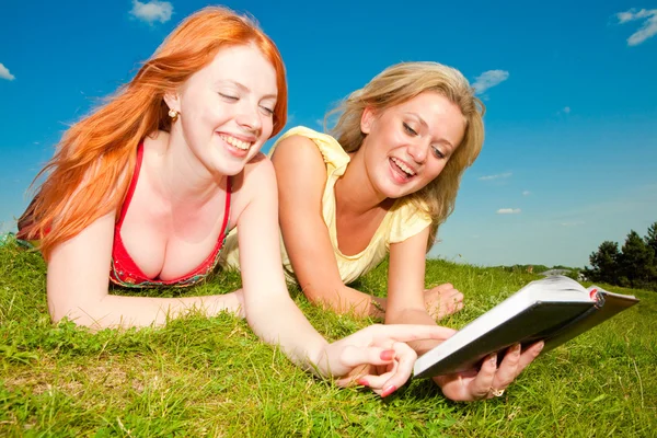 Dwie Piękne Dziewczyny Notebooków Zewnątrz Położył Się Zielonej Trawie — Zdjęcie stockowe