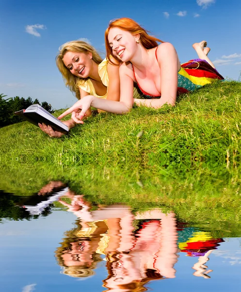 Δύο Όμορφα Κορίτσια Σημειωματάριο Εξωτερικούς Χώρους Βάλτε Στο Πράσινο Γρασίδι — Φωτογραφία Αρχείου