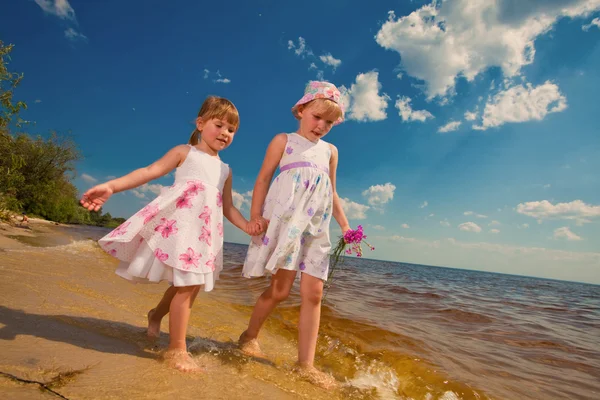 Δύο αδελφές χαριτωμένο παιχνίδι στα κύματα στην θάλασσα — Φωτογραφία Αρχείου