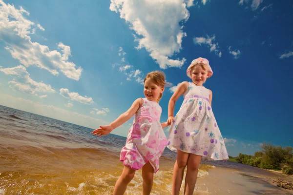两个可爱的姐妹们玩在海上的波浪 — 图库照片