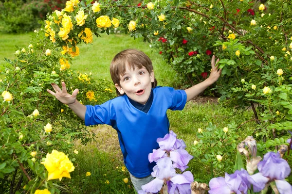 Rapaz feliz desfrutar de flores — Fotografia de Stock