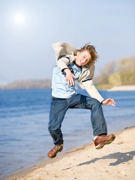 Joyeux garçon sautant sur la plage — Photo
