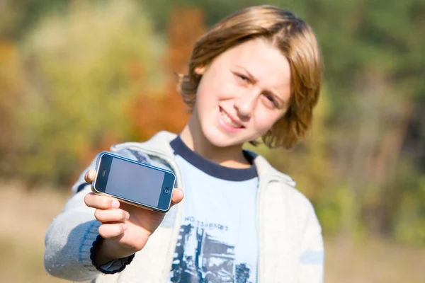 Rapaz a mostrar o telefone ao ar livre. Foco suave . — Fotografia de Stock