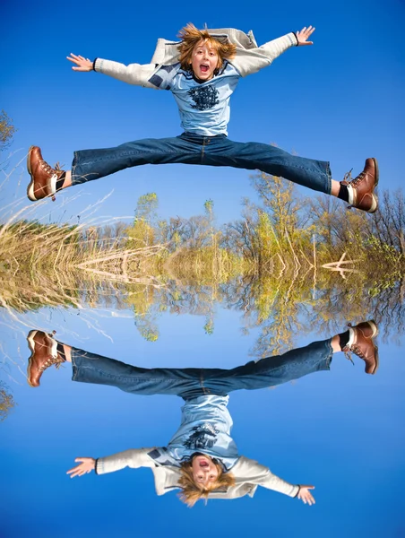 Gelukkig springen jongen. weerspiegeld in het water — Stockfoto