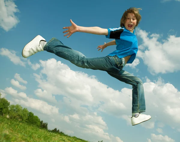 Glücklicher Junge läuft gegen schönen Himmel — Stockfoto