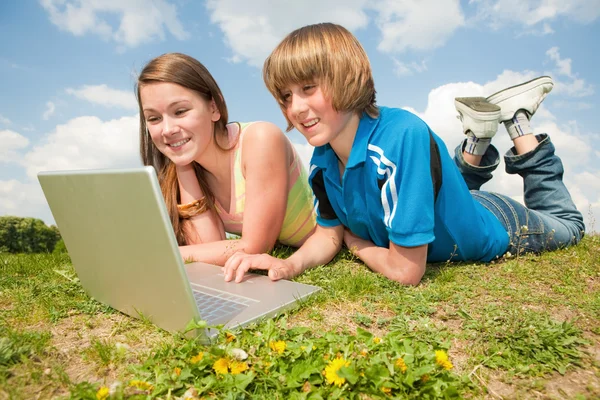 Två Leende Tonåringar Med Laptop Vilar Ängen — Stockfoto