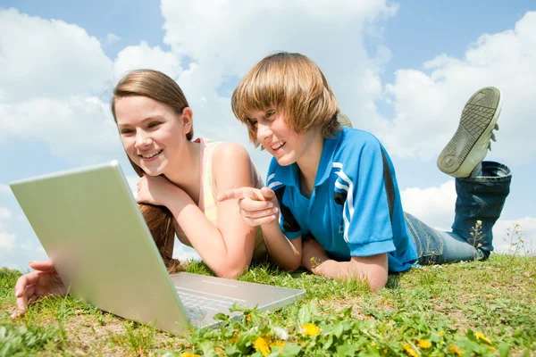 Twee Lachende Tieners Met Laptop Rusten Weide — Stockfoto
