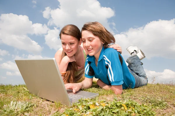 Twee Lachende Tieners Met Laptop Rusten Weide — Stockfoto