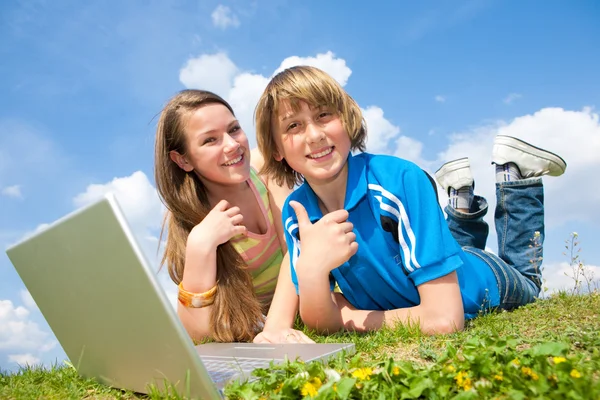 Çayır Üzerinde Dinlenme Laptop Ile Iki Gülümseyen Genç — Stok fotoğraf