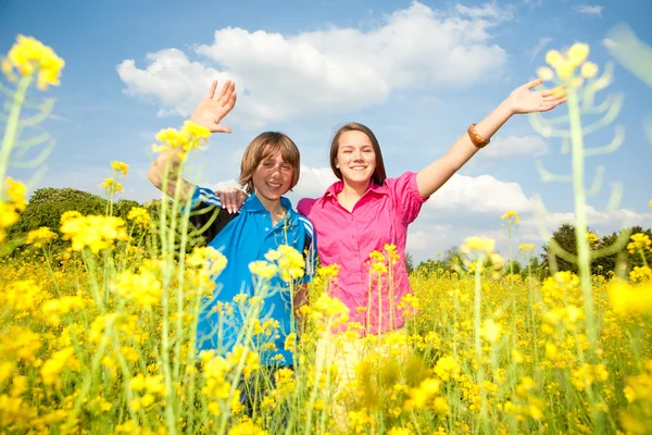女孩和男孩放松在草甸充满了黄色的花朵 软焦点 把重点放在眼睛上 — 图库照片